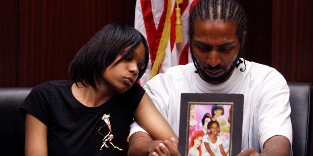 FILE - In this May 18, 2010, file photo Dominika Stanley, left, the mother of 7-year-old Aiyana Jones, sits next to Aiyana's father Charles Jones, holding Aiyana's photo, in Southfield, Mich. A member of the Detroit Police Special Response Team was charged Tuesday, Oct. 4, 2011, with involuntary manslaughter in the slaying of the 7-year-old girl who was shot to death during a raid on her home ini May 2010. (AP Photo/Carlos Osorio, File)