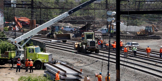 Workers labor on the site where a deadly train derailment occurred earlier in the week, Friday, May 15, 2015, in Philadelphia. Amtrak is working to restore Northeast Corridor rail service between New York City and Philadelphia. Service was suspended after a train derailed in Philadelphia on Tuesday night, killing eight passengers and injuring more than 200. (AP Photo/Julio Cortez)