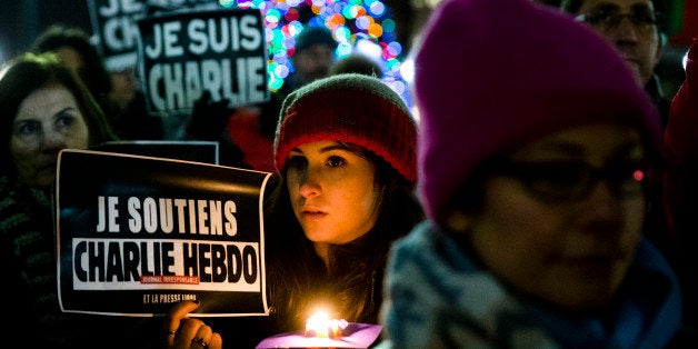 People gather to pay to pay tribute to victims of the terrorist attack against the French satirical weekly Charlie Hebdo, Friday, Jan. 9, 2015, at JFK Plaza, commonly known as Love Park, in Philadelphia. On Wednesday, masked gunmen stormed the Paris offices ofￃﾂￂﾠthe weekly newspaper that caricatured the Prophet Muhammad, killing at least 12 people, including the editor. (AP Photo/Matt Rourke)