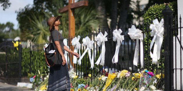 CHARLESTON, SC - JUNE 19: Cindy Samaroo pays her respects in front of the Emanuel African Methodist Episcopal Church after a mass shooting at the church that killed nine people of June 19, 2015. A 21-year-old white gunman is suspected of killing nine people during a prayer meeting in the church, which is one of the nation's oldest black churches in Charleston. (Photo by Joe Raedle/Getty Images)