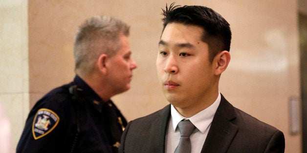 New York City rookie police officer Peter Liang, right, leaves the courtroom after his arraignment at Brooklyn Superior court, Wednesday, Feb. 11, 2015, in New York. Liang, who fired into a darkened stairwell last November at a Brooklyn public housing complex, accidentally killing 28-year-old Akai Gurley, was indicted by a grand jury in the shooting. (AP Photo/Mary Altaffer)