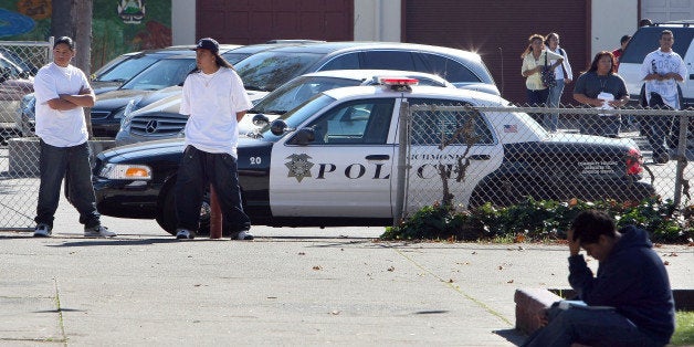 RICHMOND, CA - NOVEMBER 02: Students walk by Richmond, California police car that is parked in front of Richmond High School November 2, 2009 in Richmond, California. Faith leaders held a prayer vigil at Richmond High School to show support for a fifteen year-old student who was gang raped by several men while attending a homecoming dance. Six arrests have been made in the case. (Photo by Justin Sullivan/Getty Images)