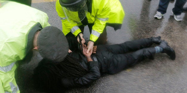An unidentified man is taken into custody after performing an act of civil disobedience at the Ferguson, Mo., police station,