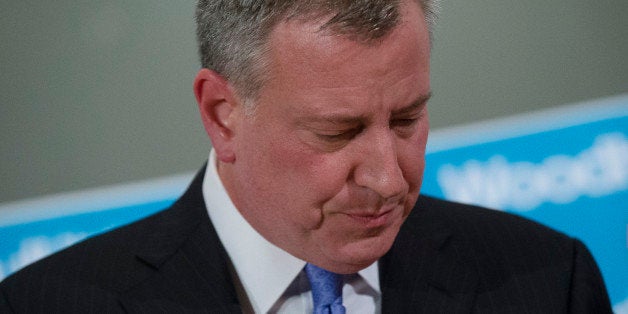 ADDS BOTH OFFICERS KILLED - New York City Mayor Bill de Blasio, pauses at the podium during a news conference at Woodhull Medical Center, Saturday, Dec. 20, 2014, in New York. An armed man walked up to two New York Police Department officers sitting inside a patrol car and opened fire Saturday afternoon, killing both officers before running into a nearby subway station and committing suicide, police said. (AP Photo/John Minchillo)