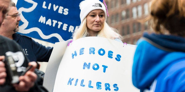 CLEVELAND, OH - DECEMBER 27: Sherry Young, a resident of Olmstead Falls, holds a sign showing support for police officers December 27, 2014, in Cleveland, Ohio. Demonstrators gathered in Public Square before marching to The Cleveland Peace Officers Memorial.(Photo by Angelo Merendino/Getty Images)