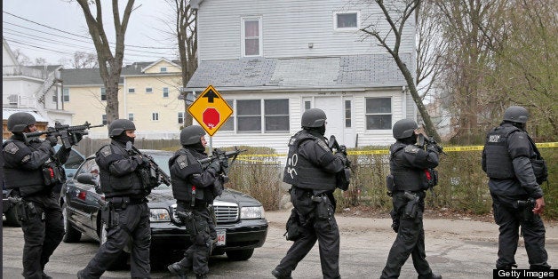 WATERTOWN, MA - APRIL 19: A SWAT team files down Nicholas Avenue during an ongoing manhunt for a suspect in the terrorist bom