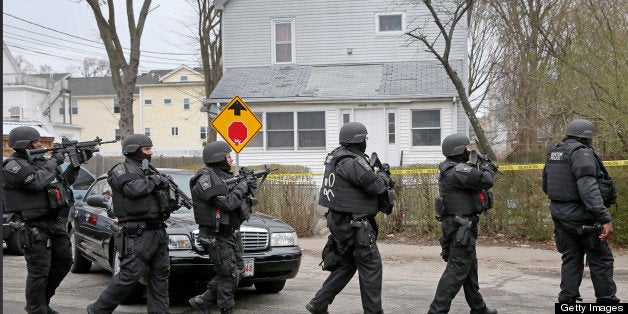 WATERTOWN, MA - APRIL 19: A SWAT team files down Nicholas Avenue during an ongoing manhunt for a suspect in the terrorist bombing of the 117th Boston Marathon earlier this week. Watertown is on lockdown following a chase and shootout in the area last night. (Photo by David L. Ryan/The Boston Globe via Getty Images)