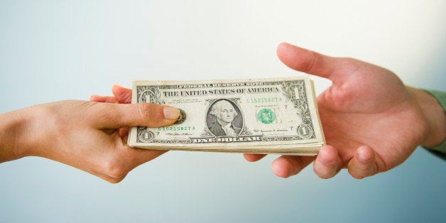 Close up of man's and woman's hands holding banknotes, studio shot