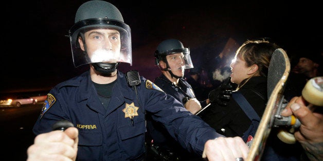 California Highway Patrol officers push back protesters who blocked Highway 80 in response to police killings in Missouri and