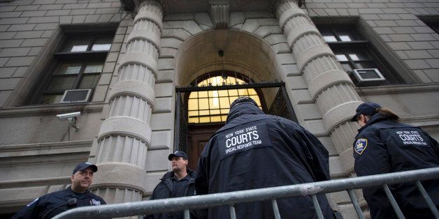 Security personnel stand outside Richmond County Supreme Court after a grand jury's decision not to indict a New York police officer involved in the death of Eric Garner, Wednesday, Dec. 3, 2014, in the Staten Island borough of New York. The medical examiner ruled Garner's death a homicide and found that a chokehold contributed to it. Police union officials and the police officers' lawyer have argued that the officer used a takedown move taught by the police department, not a chokehold, because he was resisting arrest and that Garner's poor health was the main reason he died. (AP Photo/John Minchillo)