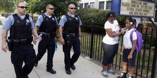 FILE - In this Aug. 26. 2013, file photo, Chicago Police patrol the neighborhood at Gresham Elementary School on the first day of classes in Chicago. Thanks to $1 million from the city, another 100 ￃﾢￂﾀￂﾜSafe Passageￃﾢￂﾀￂﾝ workers will be on routes kids walk through crime-ridden neighborhoods when classes resume Tuesday, Sept. 2, 2014. (AP Photos/M. Spencer Green, File)