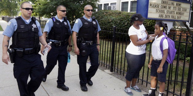 FILE - In this Aug. 26. 2013, file photo, Chicago Police patrol the neighborhood at Gresham Elementary School on the first day of classes in Chicago. Thanks to $1 million from the city, another 100 ᅢ까タᅡワSafe Passageᅢ까タᅡン workers will be on routes kids walk through crime-ridden neighborhoods when classes resume Tuesday, Sept. 2, 2014. (AP Photos/M. Spencer Green, File)
