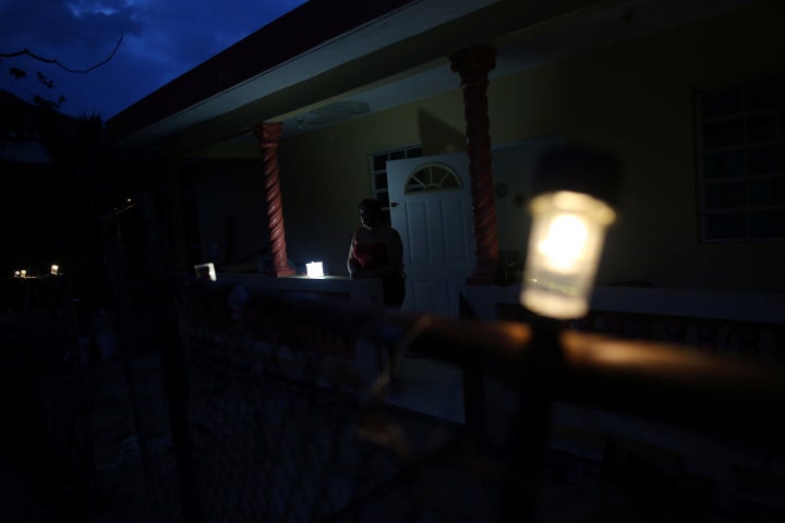 Jannet Rodriguez, 40, stands on the porch of her darkened house in Adjuntas, Puerto Rico, on May 11, 2018. Hurricane Maria left Puerto Rico's fragile power system reeling for months after the storm made landfall in September 2017.