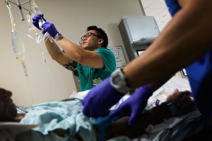 Registered Nurse Tung Tran hangs an IV bag for a patient at the University of Miami hospital's emergency department on April 30, 2012.