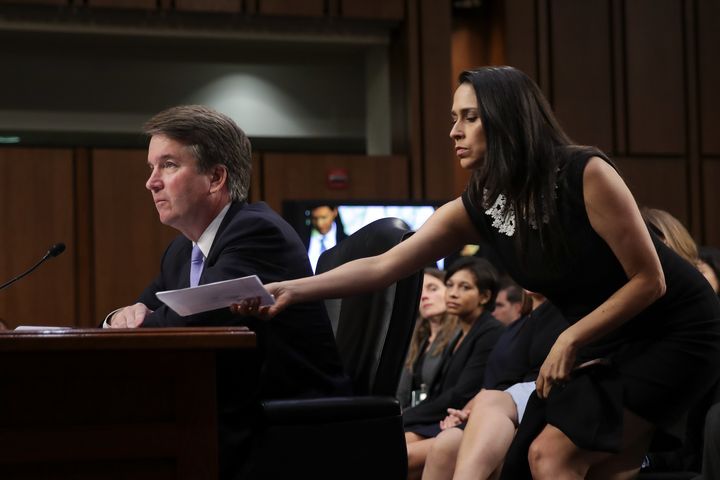 Supreme Court nominee Brett Kavanaugh testifies before the Senate Judiciary Committee earlier this month as former clerk Zina Bash hands him a note.