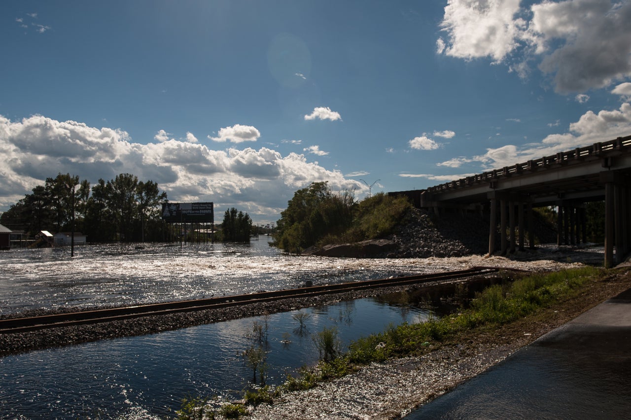 Water flows through a break in the temporary levee Tuesday.