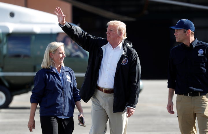 President Donald Trump waves as FEMA Director Brock Long and Homeland Security Secretary Kirstjen Nielsen walk Trump to Air F