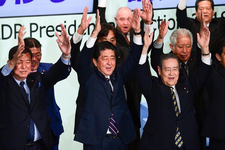 Japan's Prime Minister Shinzo Abe (C) celebrates after the ruling liberal Democratic Party (LDP) leadership election at the party's headquarters in Tokyo.