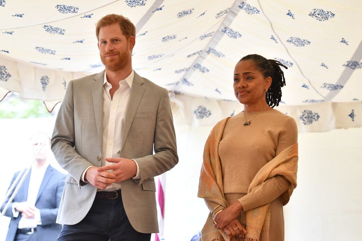 Prince Harry and Doria Ragland look on as Meghan gives a speech.