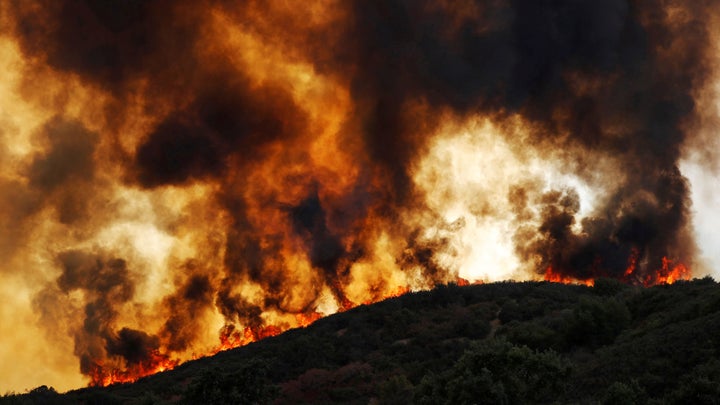 Wind-driven flames roll over a hill toward homes during the River fire near Lakeport, California, on Aug. 2.