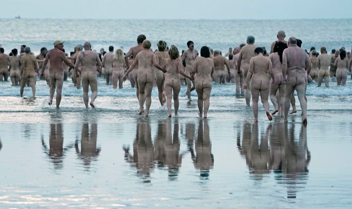 People take part in the North East Skinny Dip at Druridge Bay in Nothumberland.