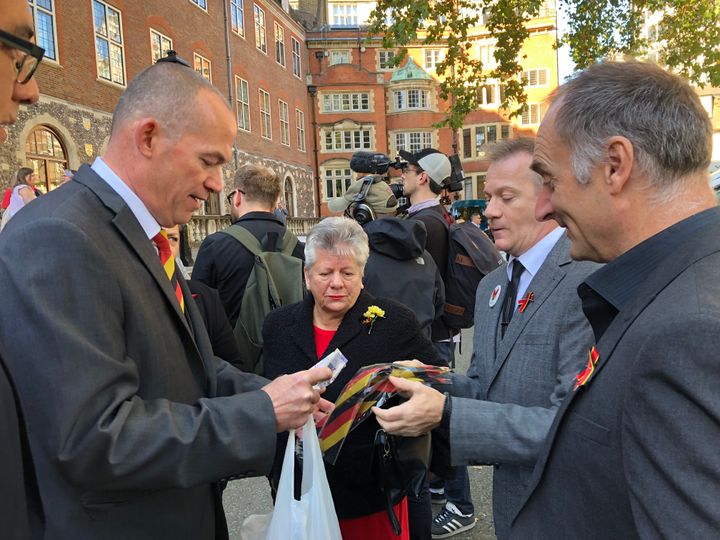 Tony Farrugia (left) shows blood campaign ties worn by many to the inquiry opening this morning to Mark Ward and his family as they arrive. Mark was infected with HIV as a teenager