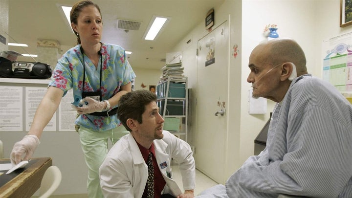 <p>Dr. Joseph Bick, center, talks to hepatitis C patient Richard Carreiro, as nurse Laura Escareno-Scarrott watches in a Vacaville, California, hospice in this file photo. Recent court rulings and settlements have forced states to provide hepatitis C cures to inmates and Medicaid beneficiaries. </p>