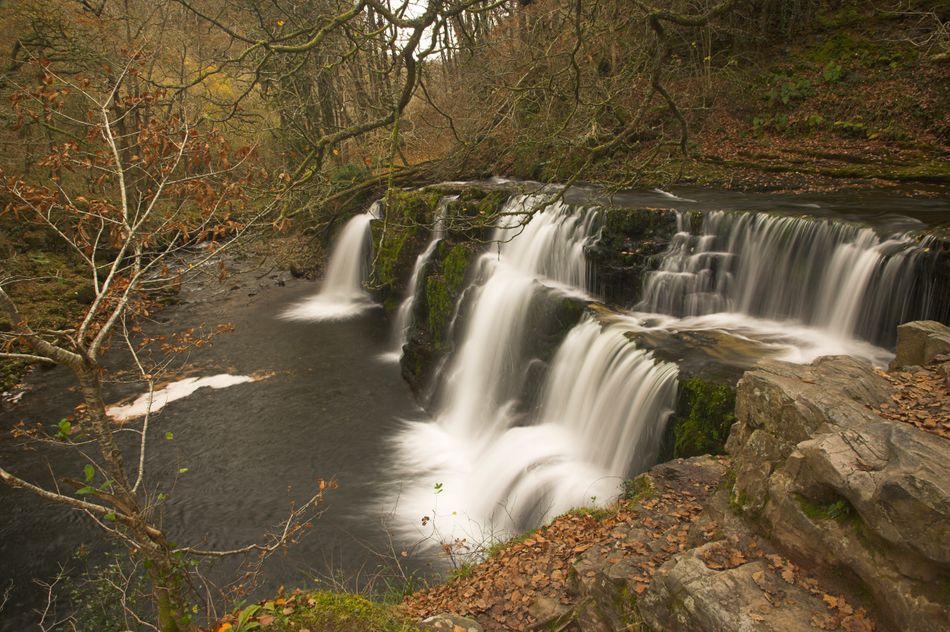 You&rsquo;ll need a car to get from either Swansea or Cardiff to Ystradfellte in the Brecon Beacons National Park in around 1.5 hours. Some of the rocky path on this exhilarating riverside walk needs a bit of clambering over. &nbsp;But the reward is stunning limestone scenery, with woods and meadows, an intriguing cave, and no less than four very different cascading waterfalls, one of which you can actually walk behind while on the path.Brecon Beacons Four Waterfalls Walk