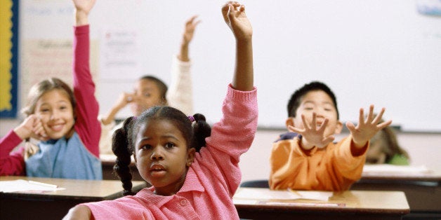 School children raising their hands in class