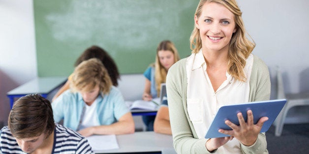 Portrait of female teacher using digital tablet in her class