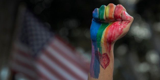 LOS ANGELES, CA - JUNE 13: A defiant fist is raised near an American flag at a vigil for the worst mass shooing in United States history on June 13, 2016 in Los Angeles, United States. A gunman killed 49 people and wounded 53 others at a gay nightclub in Orlando, Florida early yesterday morning before suspect Omar Mateen also died on-scene. (Photo by David McNew/Getty Images)