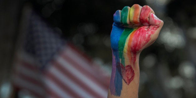 LOS ANGELES, CA - JUNE 13: A defiant fist is raised near an American flag at a vigil for the worst mass shooing in United Sta