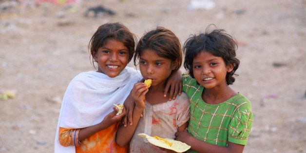 Poor girls living at the bank of Ravi River Near Lahore, might be the poorest area, are Smiling after receiving the Roti (bread) and sharing with each other.