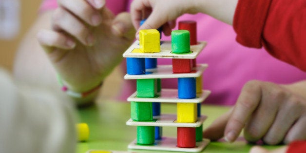 Children playing with homemade, do-it-yourself educational toys, stacking and arranging colorful pieces. Learning through experience concept, gross and fine motor skills, back to school concept.