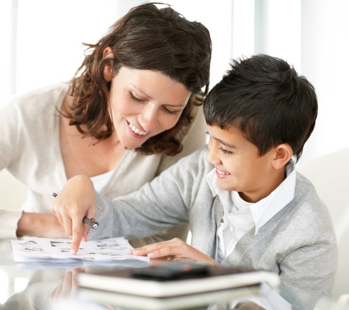 Portrait of a sweet mature woman and boy reading a book together