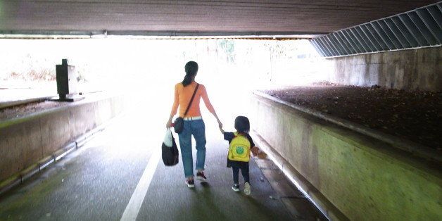 Mother and child walking on road.