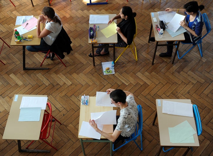 French students work on the test of Philosophy as they take the baccalaureat exam (high school graduation exam) on June 18, 2
