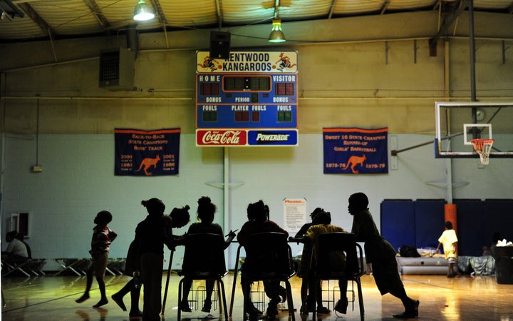 Children try to do their homework at an evacuation shelter in a high school gymnasium in Kentwood, northeast of New Orleans on August 30, 2012 in Louisiana, where Tropical Storm Isaac has dumped more rain onto an already saturated Gulf Coast leaving residents to seek safety from flooding. Authorities in two states along the US Gulf Coast urged residents to seek shelter amid fears the Percy Quin dam in Mississippi near the Louisiana border showed signs of damage due to the storm. AFP PHOTO / Frederic J. BROWN (Photo credit should read FREDERIC J. BROWN/AFP/GettyImages)