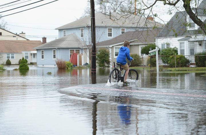 POINT PLEASANT BEACH, NJ - OCTOBER 30: A young boy rides a bike through Hurricane Sandy floodwaters on October 30, 2012 in Point Pleasant Beach, New Jersey. The storm left around 2.5 million people in the state without power, claimed entire boardwalks, and flooded and evacuated towns on and off the New Jersey shore. (Photo by Michael Loccisano/Getty Images)