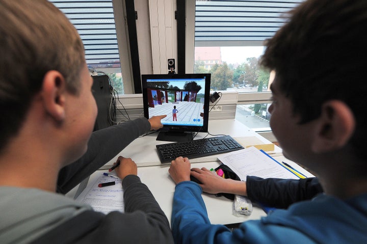 TO GO WITH AFP STORY BY CEDRIC SIMON - Koerbele high school students use a computer software recreating an imaginary city, on