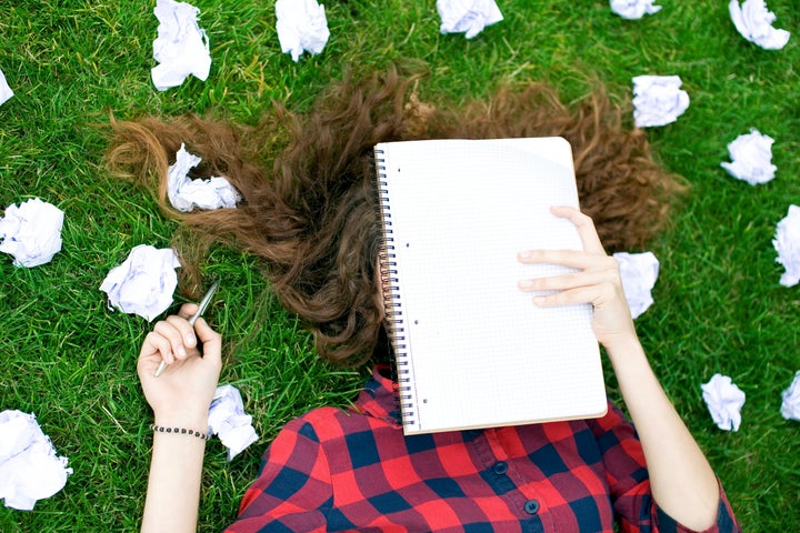 Female Student Surrounded by Crumpled Paper