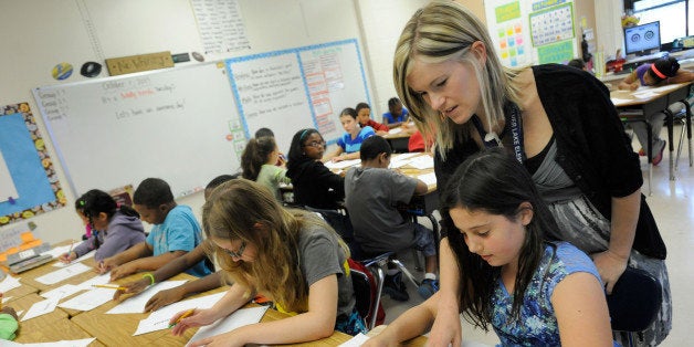 Amy Lawson, a fifth-grade teacher at Silver Lake Elementary School in Middletown, Del., helps student Melody Fritz with an English language arts lesson Oct. 1, 2013. Silver Lake has begun implementing the national Common Core State Standards for academics. Remembering the plot of a short story is no longer good enough in Lawson?s fifth-grade classroom. Now, students are being asked to think more critically -- what, for example, might a character say in an email to a friend. "It?s hard. But you can handle this," Lawson tells them. Welcome to a classroom using the Common Core State Standards, one of the most politicized and misunderstood changes in education for students and their teachers in grades kindergarten through high school. (AP Photo/Steve Ruark)