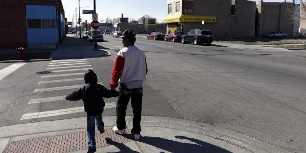 In this April 3, 2013 photo, a child leaves Dvorak Technology Academy with his grandfather at the end of the school day in Chicago. While the school serves as a safe haven for children during classroom hours, their journeys to and from home during the school year are subject to peril as they cross gang borders that divide Chicago's neighborhoods. As Chicago Public Schools prepares to close 54 schools in an attempt to rescue an academically and financially failing educational system, one of its greatest challenges will be safely maneuvering thousands of students to and from schools in the nationâs third-largest city. (AP Photo/M. Spencer Green)