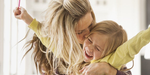 USA, Utah, Lehi, Mother kissing daughter (6-7) during doing homework