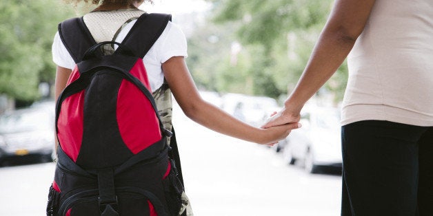 african american mom and daughter hold hands while walking