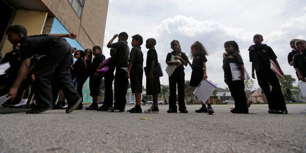 Students wait in line at ReNEW SciTech Academy, a charter school in New Orleans, Thursday, Aug. 14, 2014. Nine years after Hu