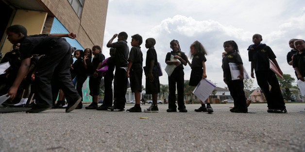 Students wait in line at ReNEW SciTech Academy, a charter school in New Orleans, Thursday, Aug. 14, 2014. Nine years after Hurricane Katrina, charter schools are the new reality of public education in New Orleans. The vast majority of public school students will be attending a charter school established by a state-run school district created in the wake of the storm. (AP Photo/Gerald Herbert)