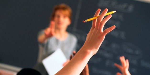 Teacher pointing to raised hands in classroom