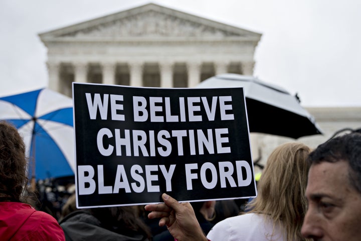 A demonstrator holds a "We Believe Christine Blasey Ford" sign outside the U.S. Supreme Court in Washington on Sept. 24.