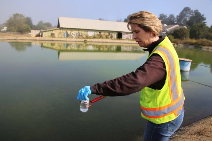 <em>Kara Waugaman collects a water sample from a concrete-lined reservoir at Seascape Ranch near Watsonville, Calif. Over yea